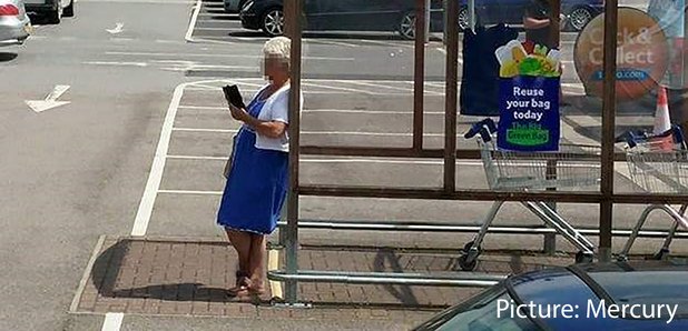 Woman waits for bus at trolley bay